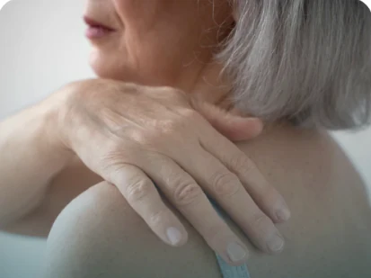 Mulher madura tocando o ombro, referência visual a dores articulares