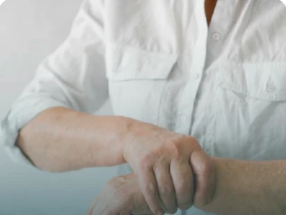 Pessoa massageando o próprio punho, referência visual ao desconforto musculoesquelético