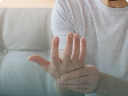 Pessoa segurando o punho e a mão, referência visual à dor articular